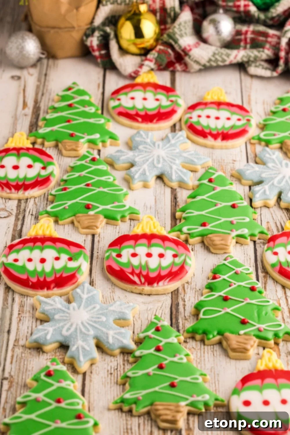 Adorned Sugar Cookies: Soft, Shapely, and Icing-Ready 38 Decorated Sugar Cookies on a table shaped like snowflakes, ornaments, and Christmas trees.