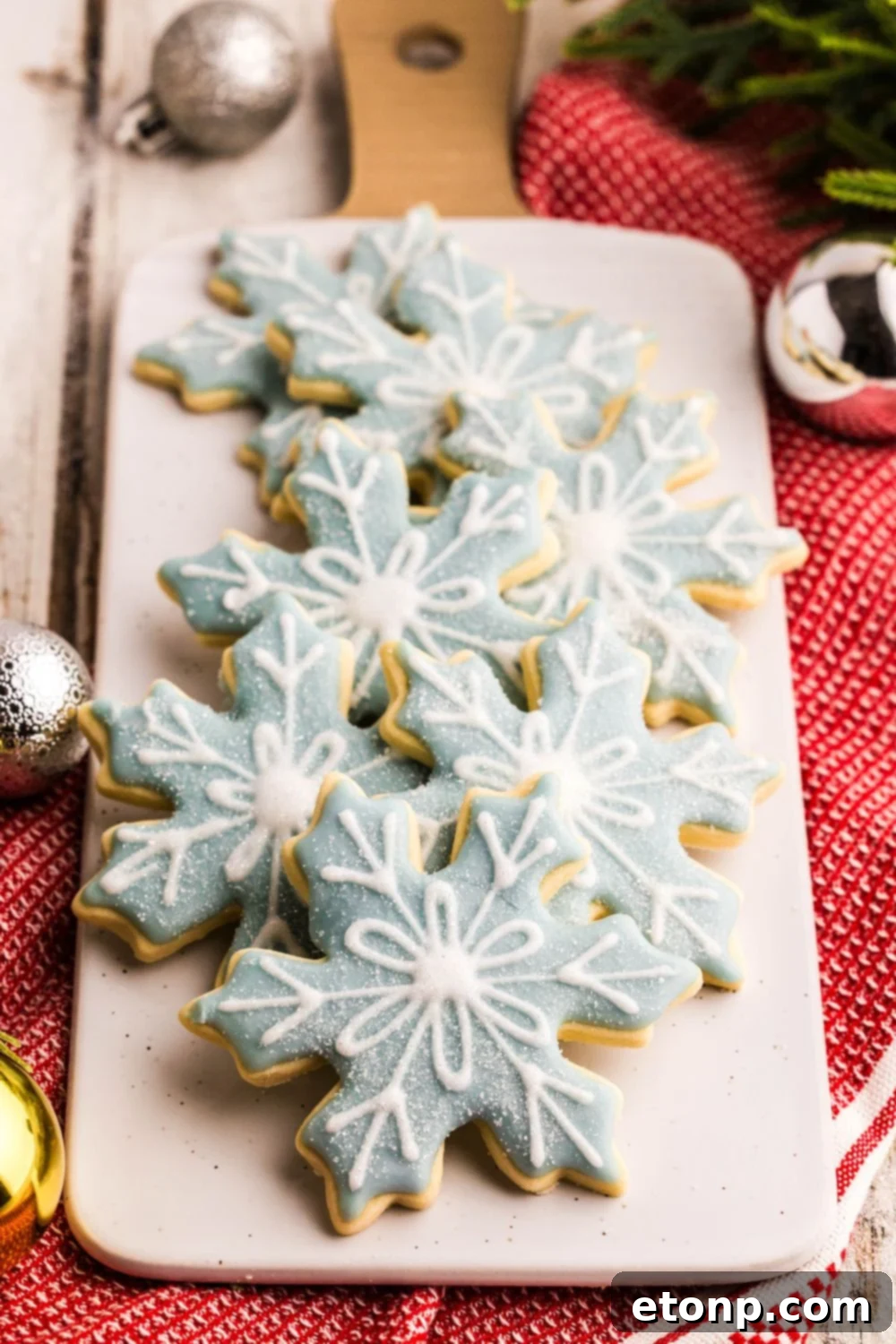 Adorned Sugar Cookies: Soft, Shapely, and Icing-Ready 5 Snowflake-shaped sugar cookies on a tray with Christmas decorations.