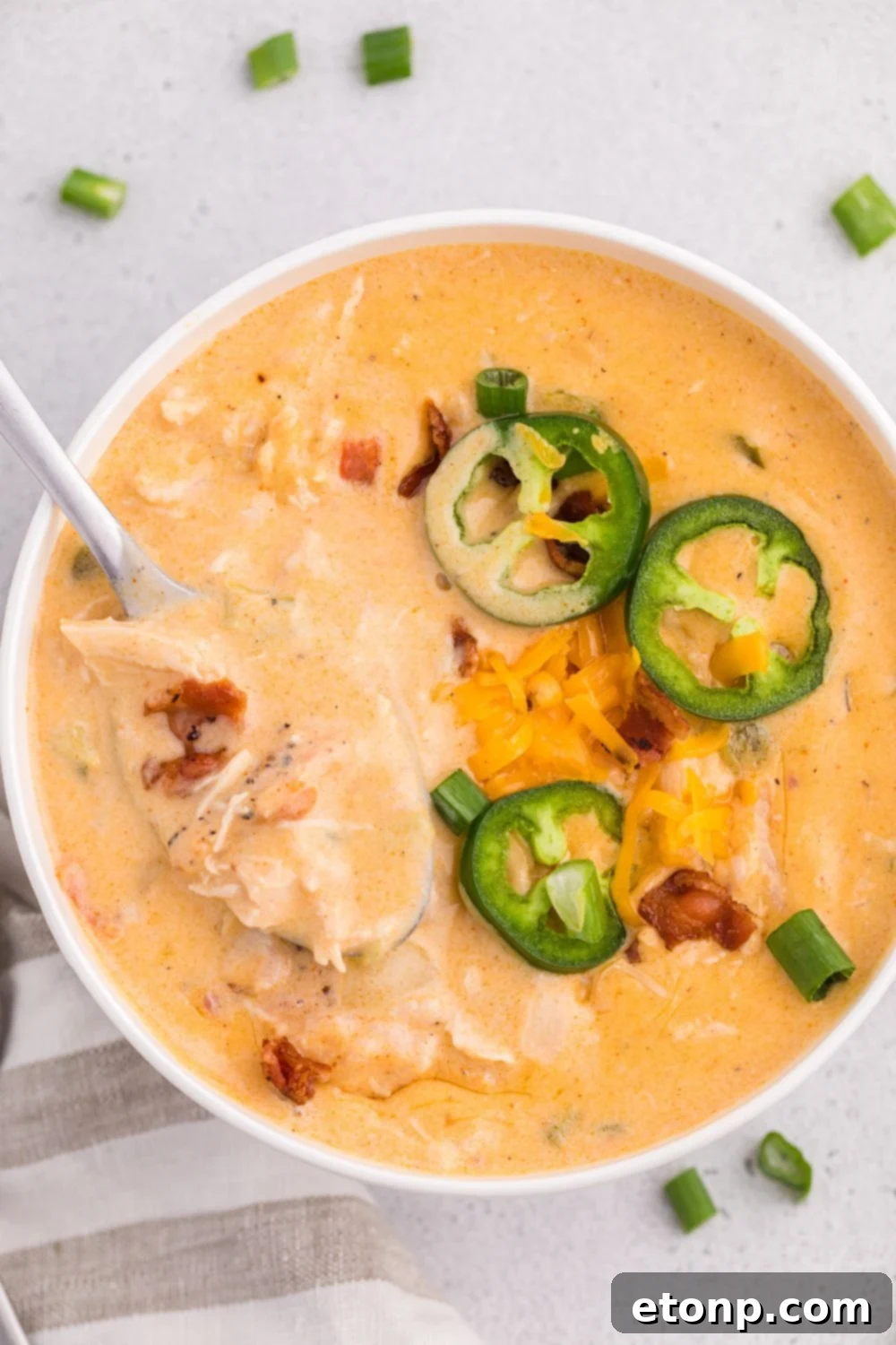 Jalapeño popper crack chicken soup in a white plate with jalapeño slices
