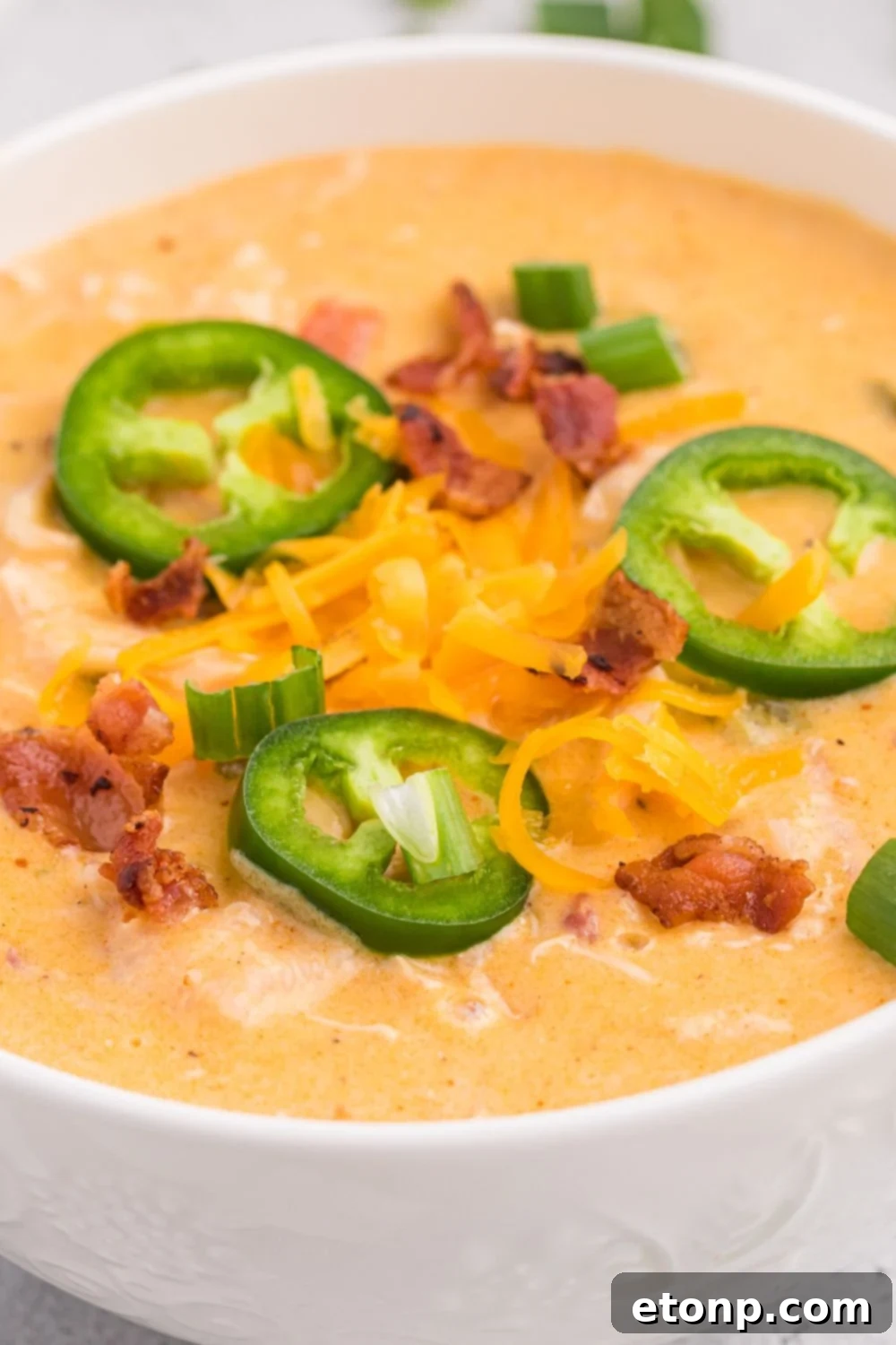 Close up of jalapeno soup in a white bowl on table
