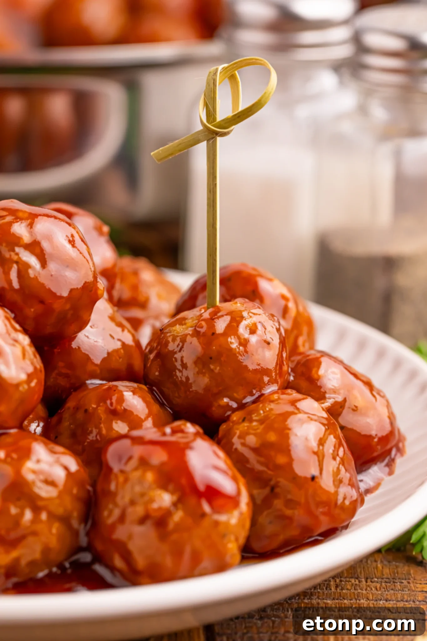 A plate of Peach BBQ Meatballs with toothpicks, ready for serving.