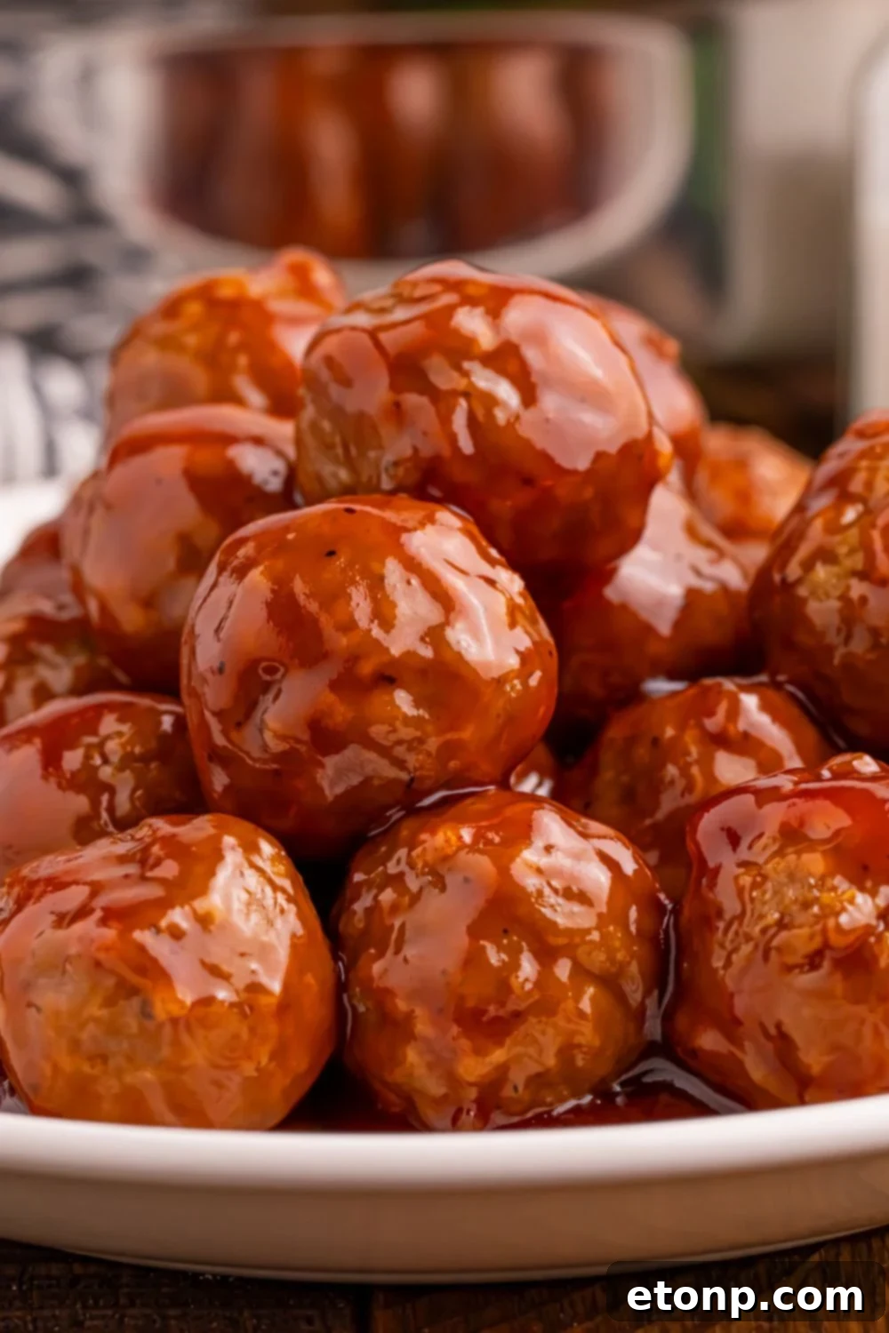 A close-up view of a stack of Peach BBQ Meatballs showcasing the glossy glaze.