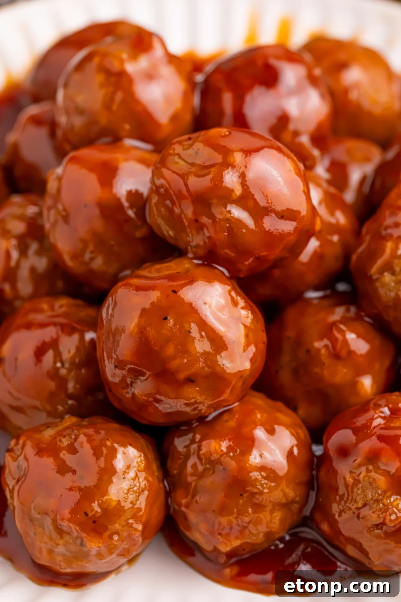 Up close shot of a white Plate of Peach BBQ Meatballs.