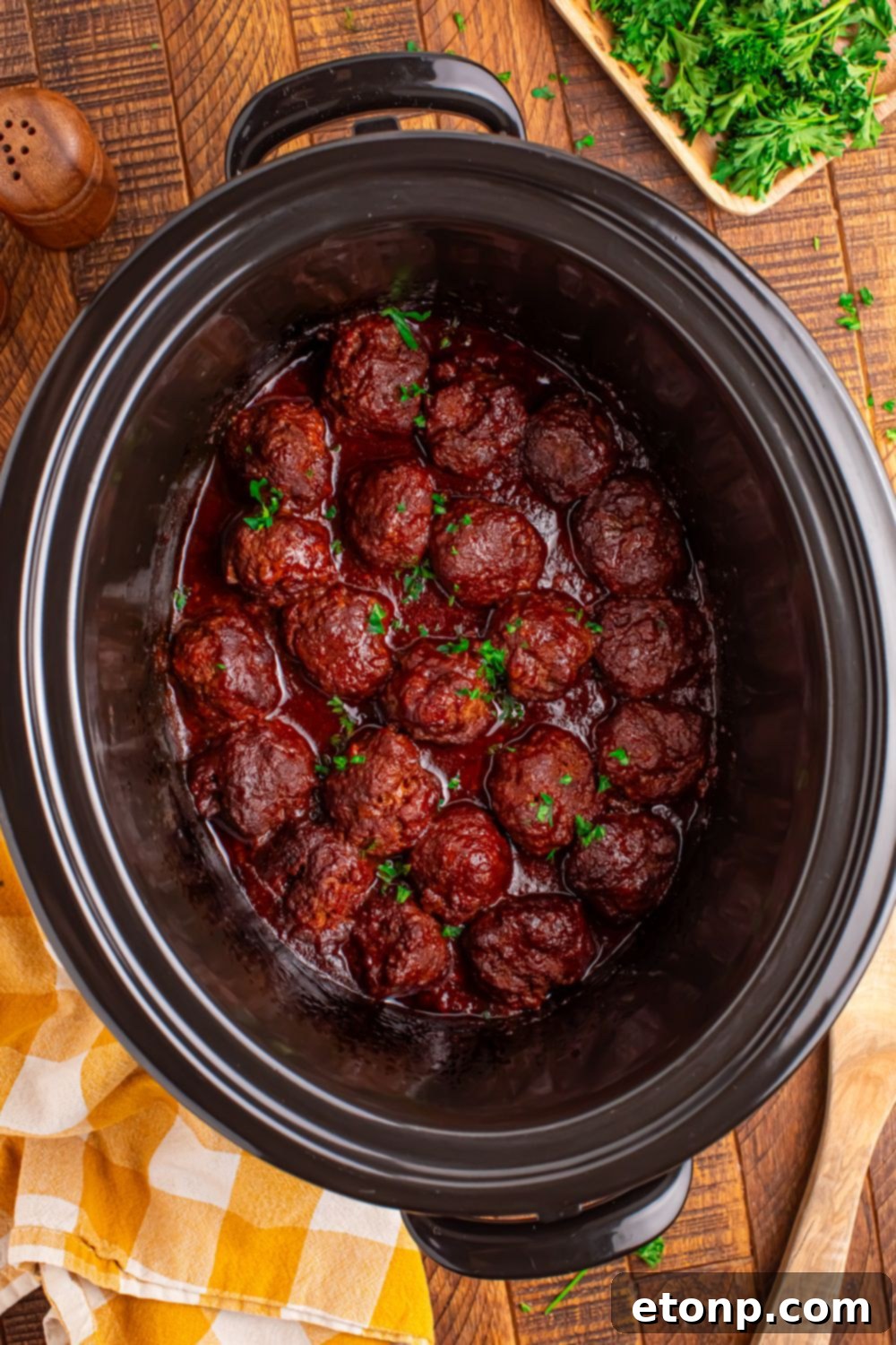 Slow-Cooker BBQ Meatball Magic 14 CrockPot full of cooked homemade meatballs, garnished with parsley
