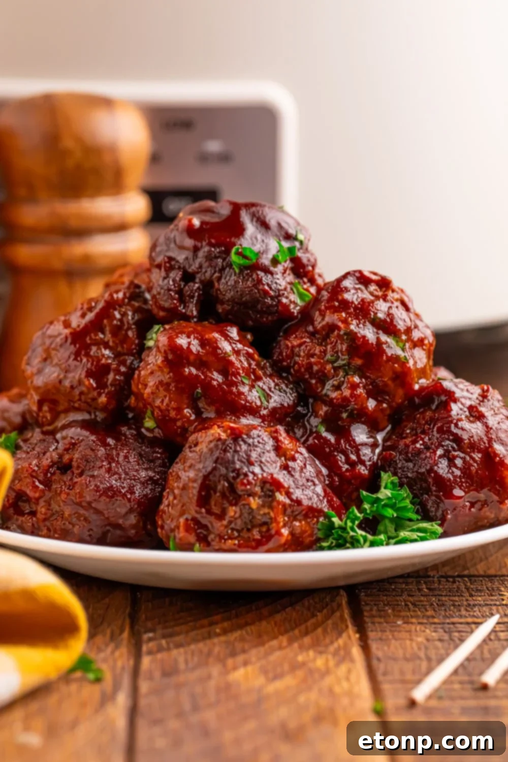 Slow-Cooker BBQ Meatball Magic 19 Crockpot Homemade BBQ Meatballs stacked on a plate with parsley and toothpicks