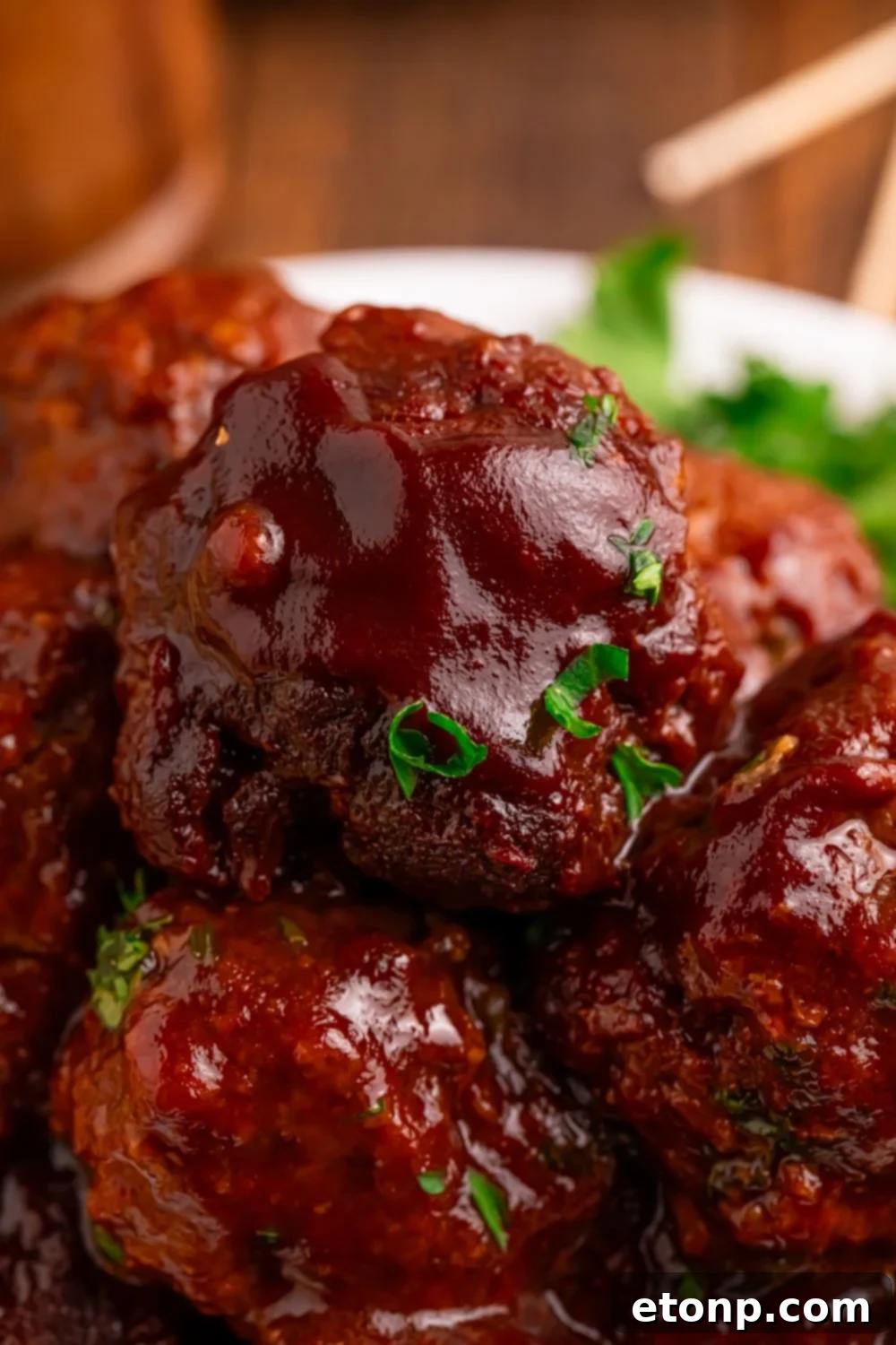 Slow-Cooker BBQ Meatball Magic 24 Crockpot Homemade BBQ Meatballs stacked on a plate, garnished