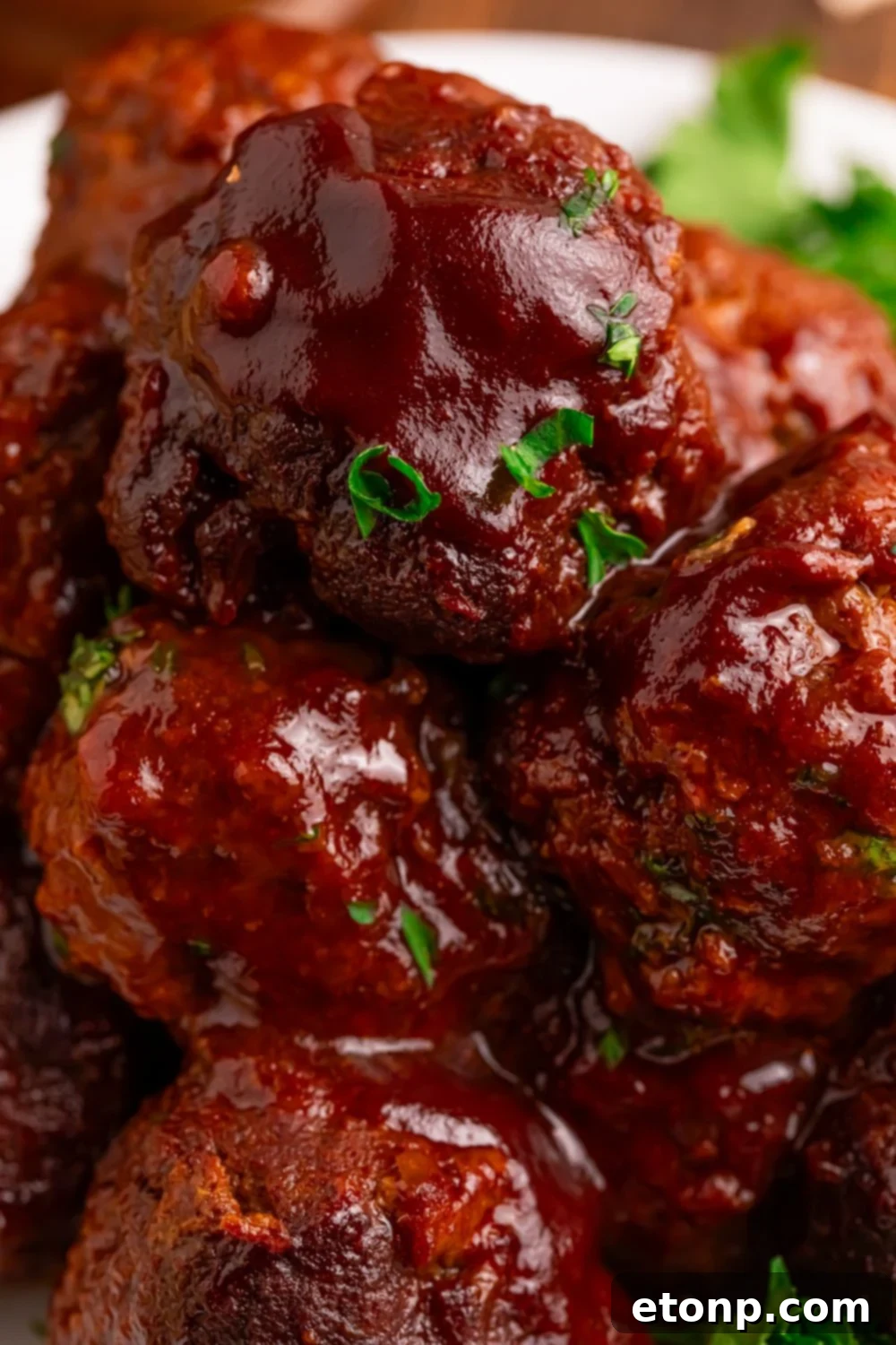 Slow-Cooker BBQ Meatball Magic 7 Crockpot Homemade BBQ Meatballs stacked high on a plate with fresh herbs