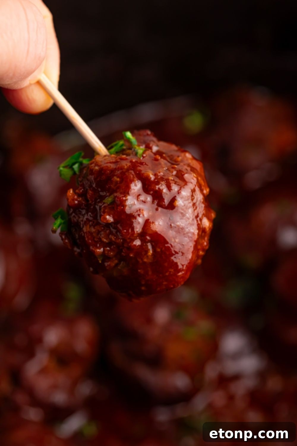 Slow-Cooker BBQ Meatball Magic 8 A homemade BBQ meatball served on a toothpick