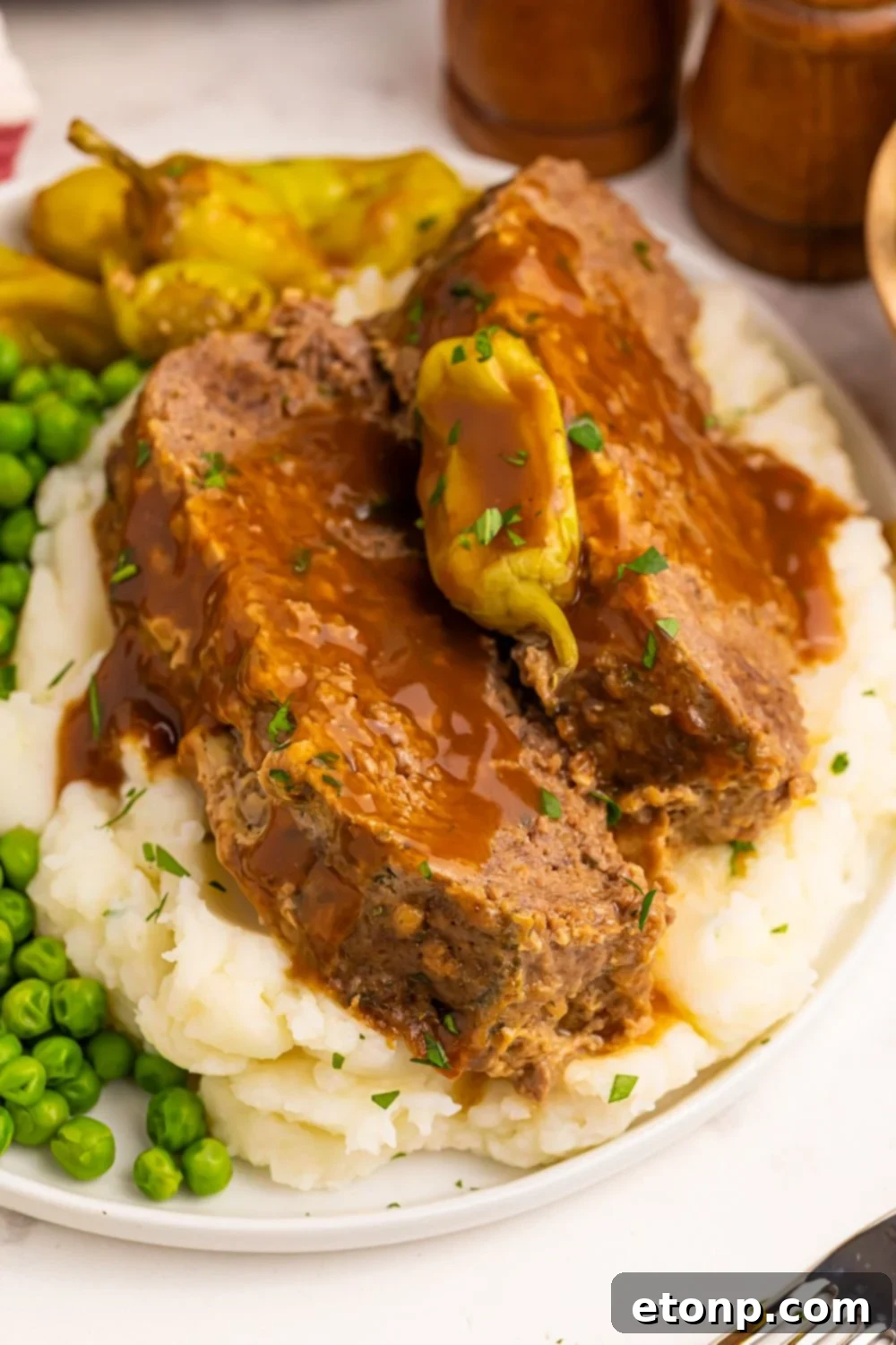 Sliced Crockpot Mississippi Meatloaf on mashed potatoes