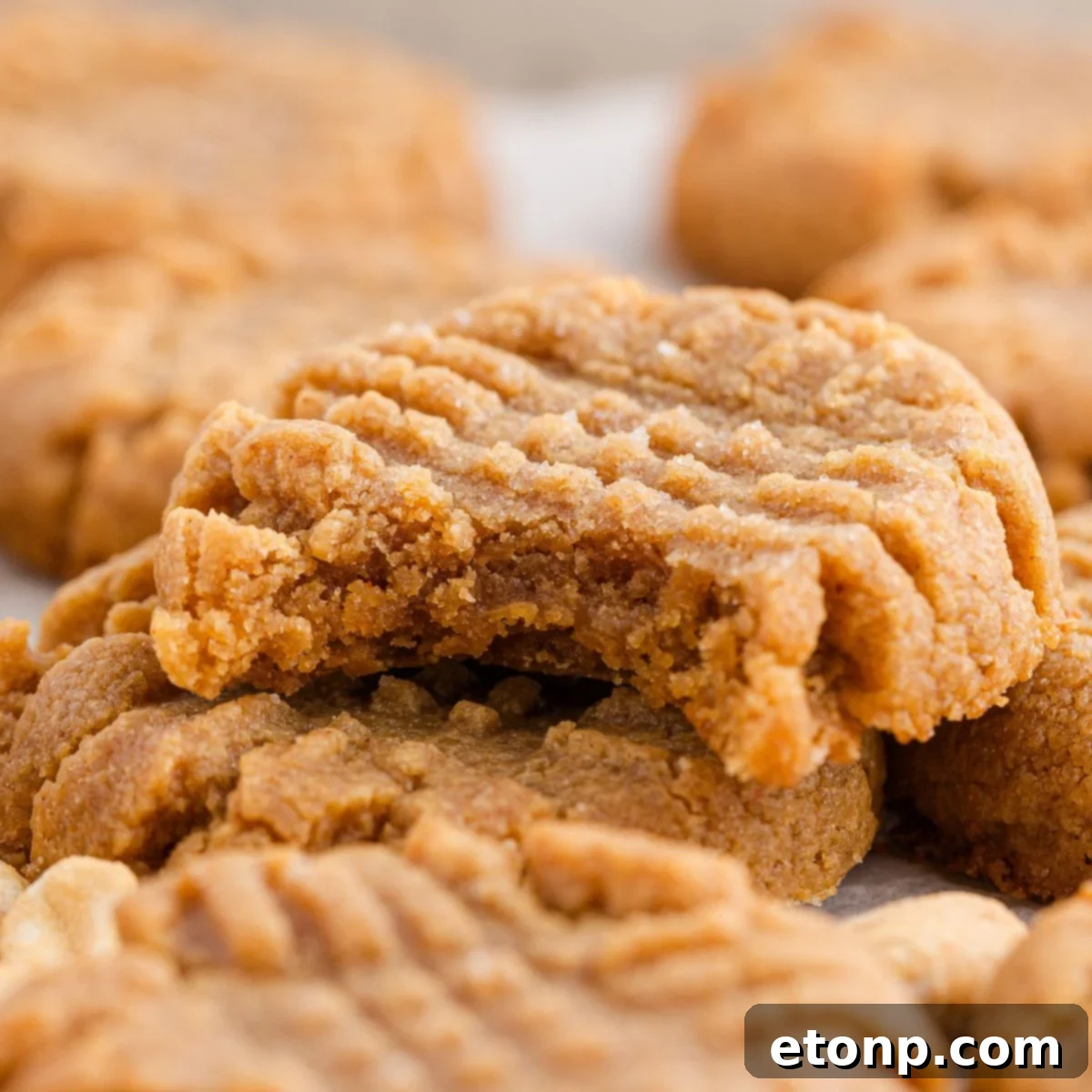 Four-Ingredient Peanut Butter Bliss: The Simplest Cookie Recipe Ever 3 Four Ingredient Peanut Butter Cookies stacked with a bite taken out