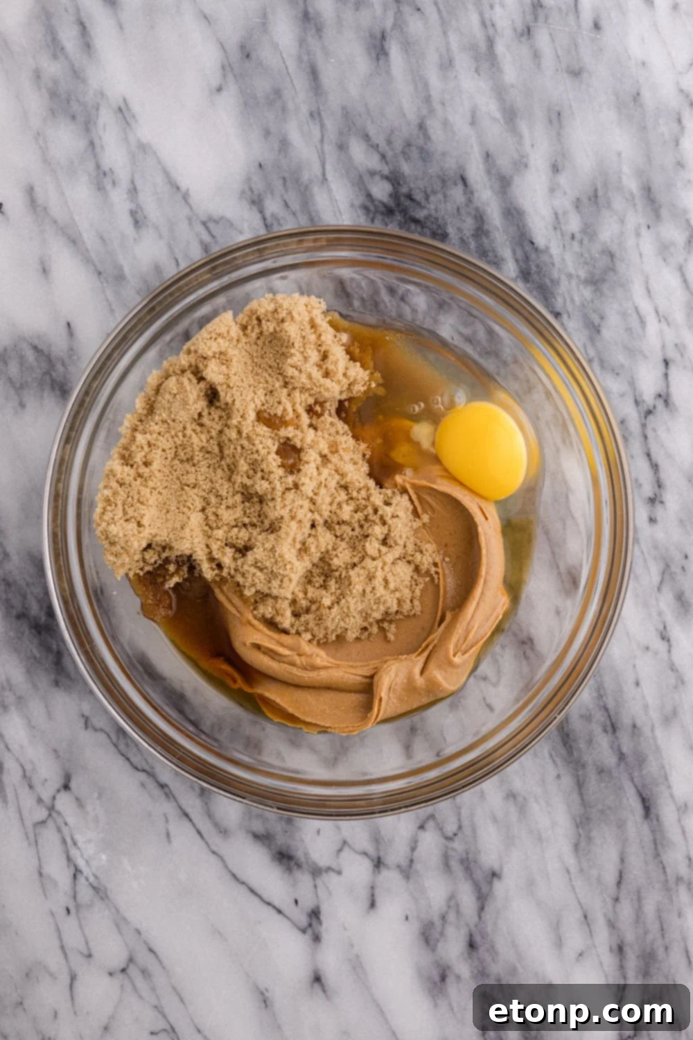 Four-Ingredient Peanut Butter Bliss: The Simplest Cookie Recipe Ever 6 Peanut butter and egg mixture in a glass bowl