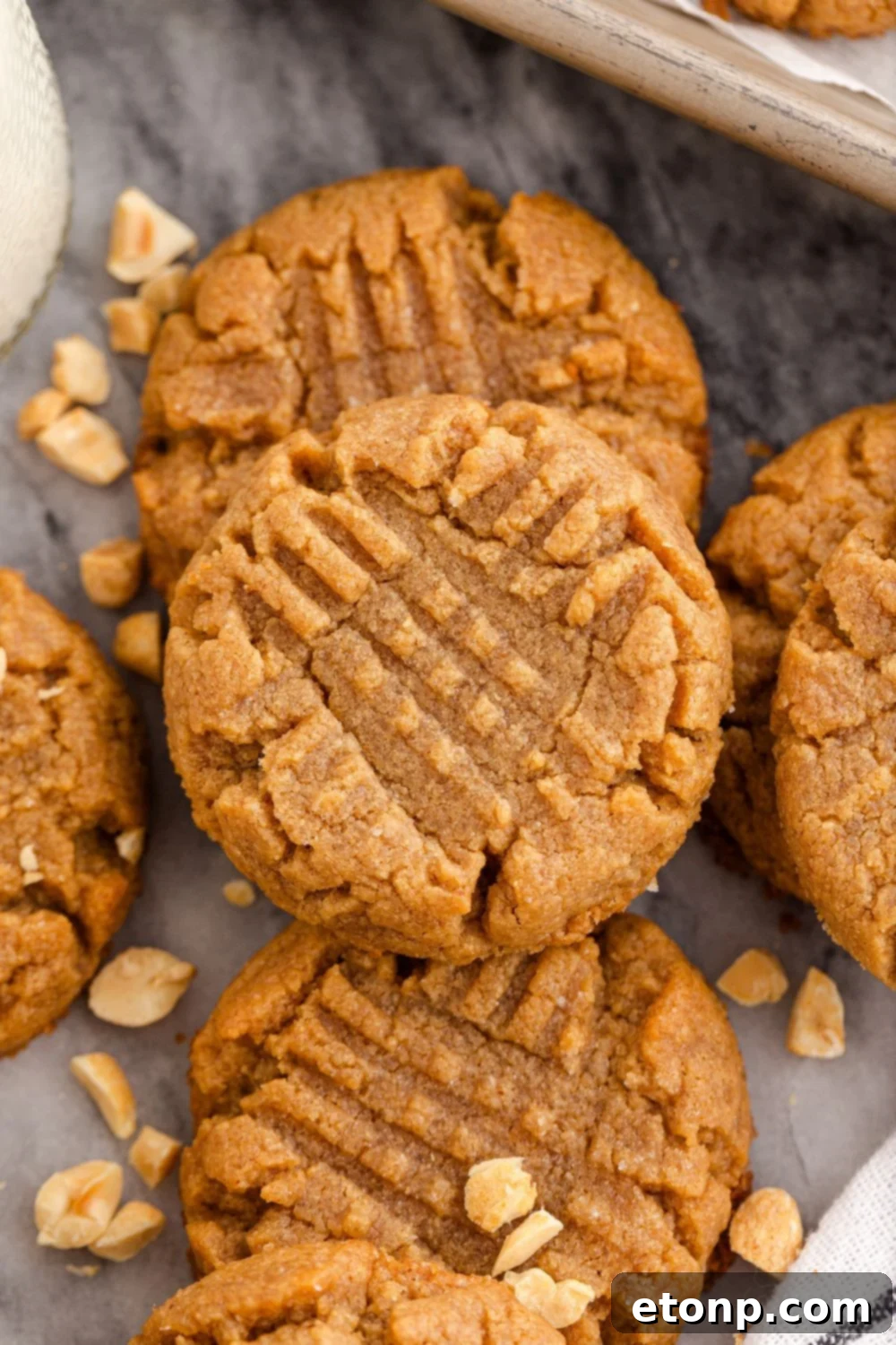 Four-Ingredient Peanut Butter Bliss: The Simplest Cookie Recipe Ever 10 Four Ingredient Peanut Butter Cookies spread around the table with peanuts