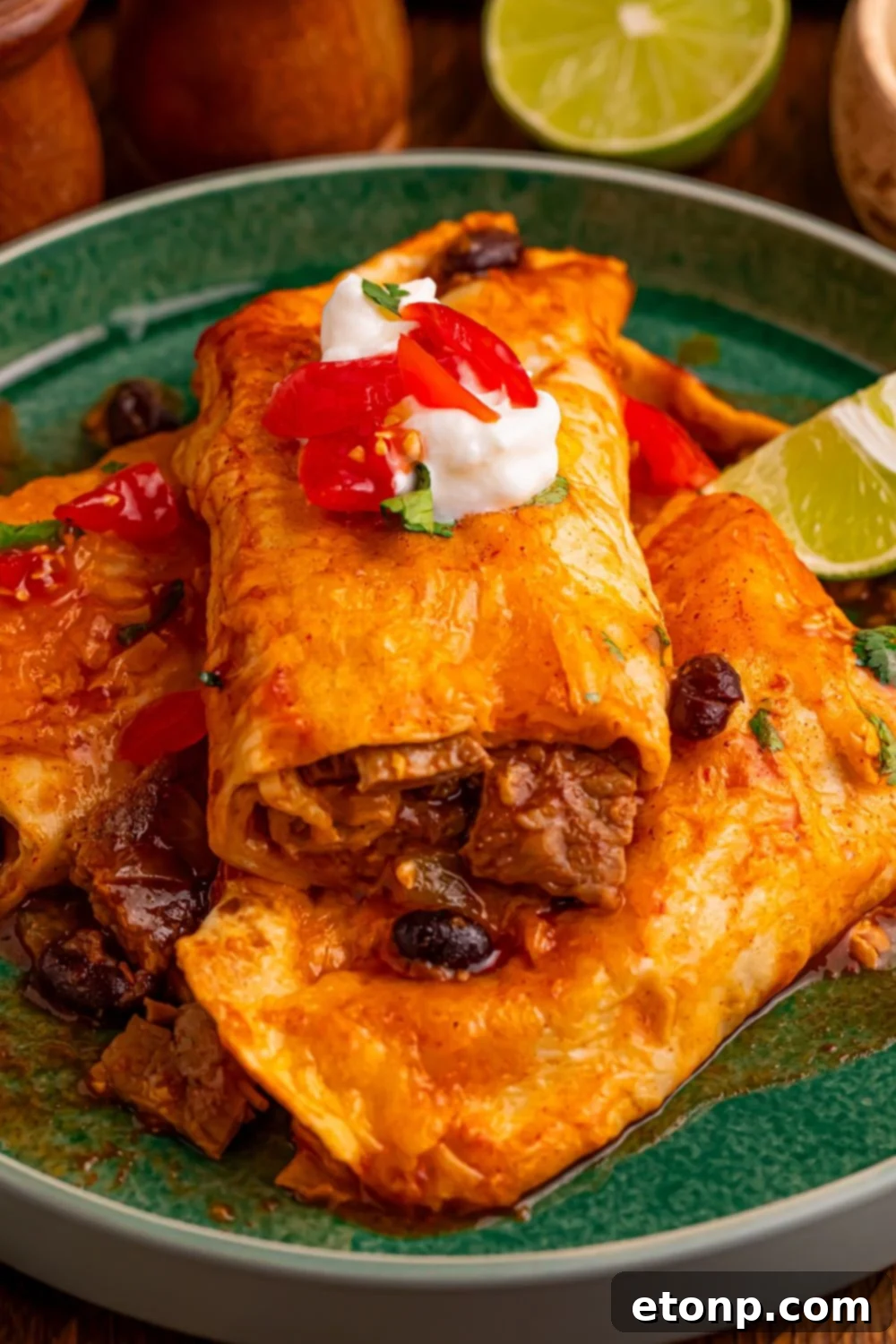 Beefy Enchiladas: A Fiesta of Flavor 11 Steak Enchiladas plated with sour cream, salsa, and lime