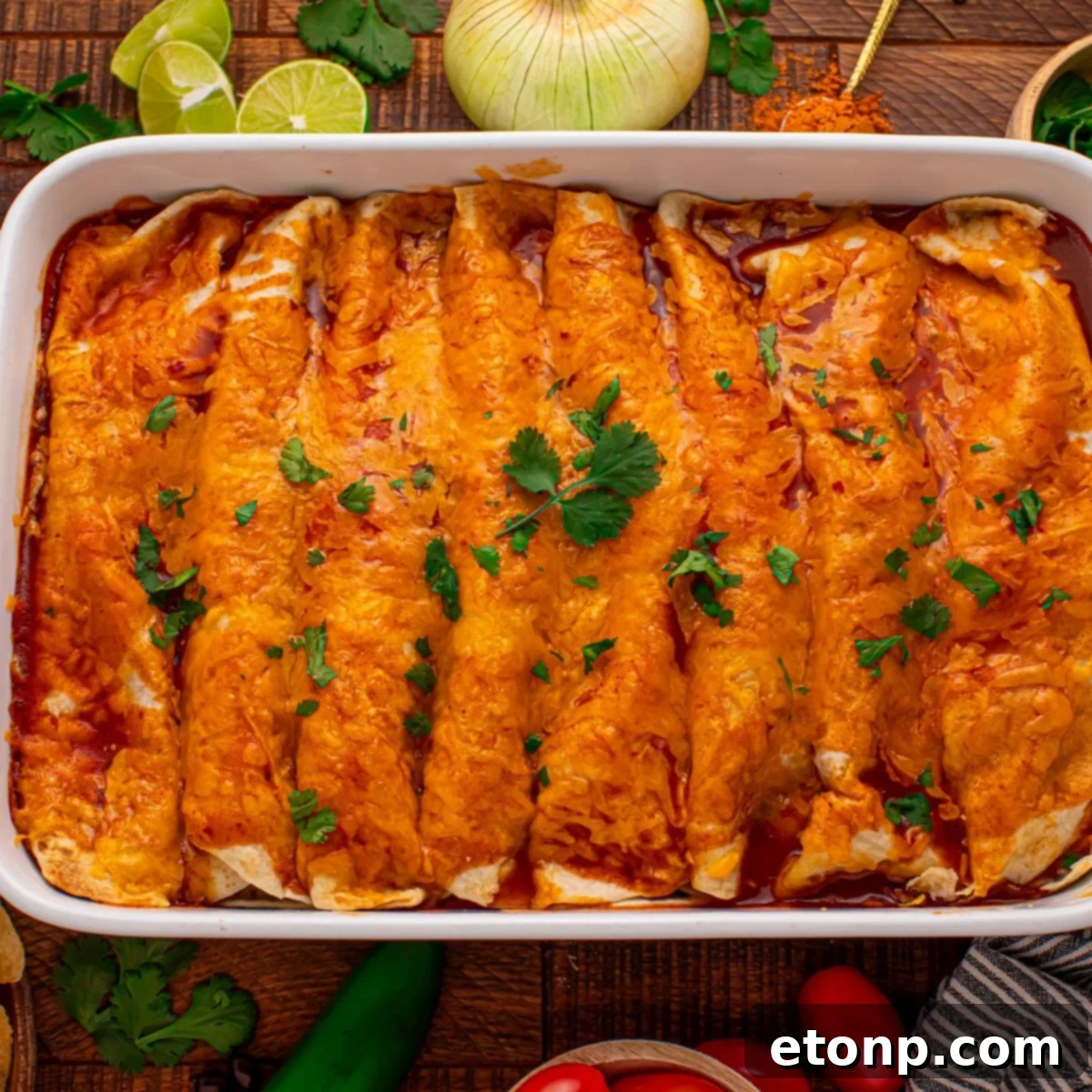 Beefy Enchiladas: A Fiesta of Flavor 3 Steak Enchiladas in a casserole dish with lime, onion, and cilantro