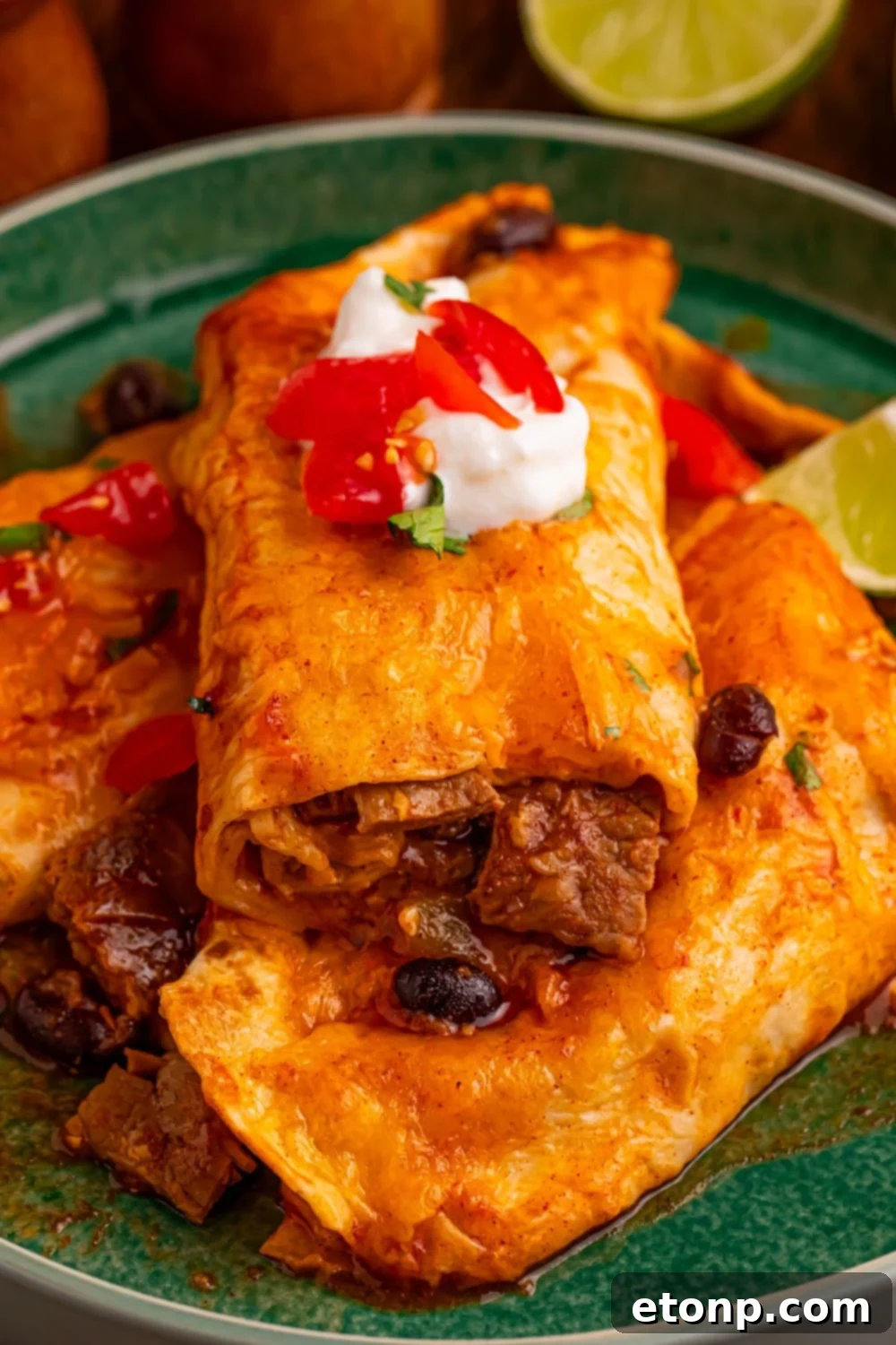 Beefy Enchiladas: A Fiesta of Flavor 21 Steak Enchiladas plated with sour cream, salsa, and lime