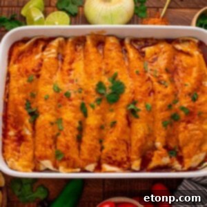 Beefy Enchiladas: A Fiesta of Flavor 26 Steak Enchiladas in a casserole pan sitting on a wooden table with sliced limes, onion and cilantro behind the casserole dish
