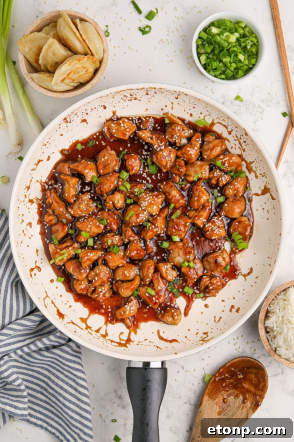 Bourbon Chicken in a skillet with green onions