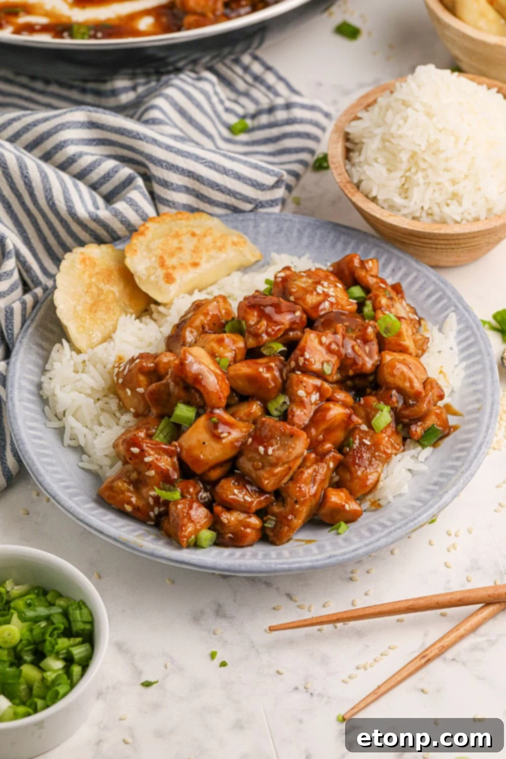 Table full of Bourbon Chicken, rice, and side dishes