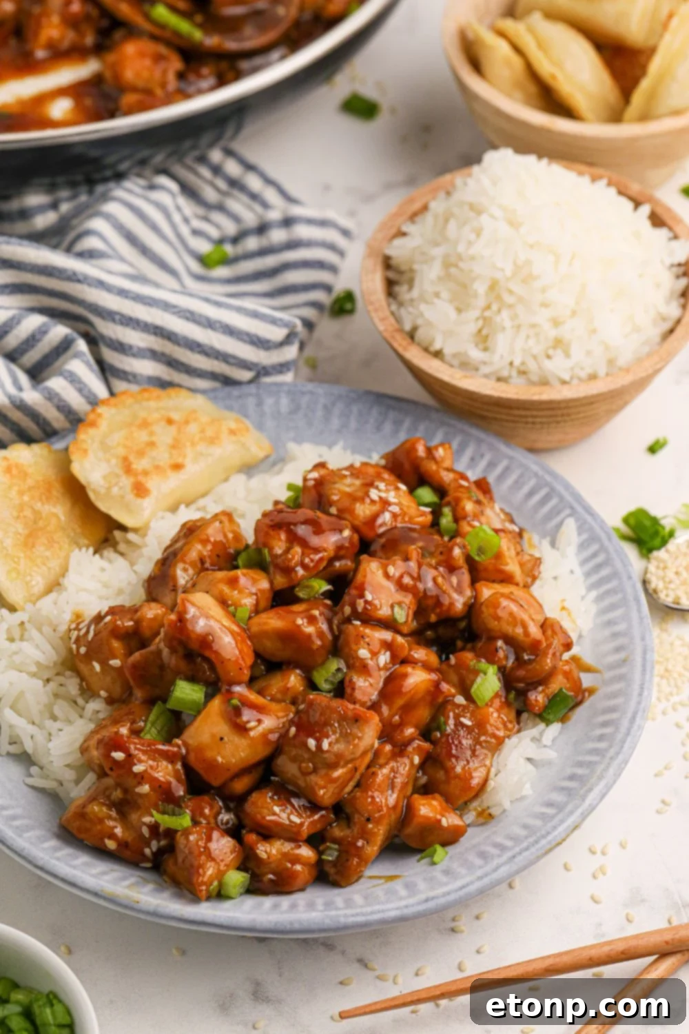 Bourbon Chicken with rice and bread on a table