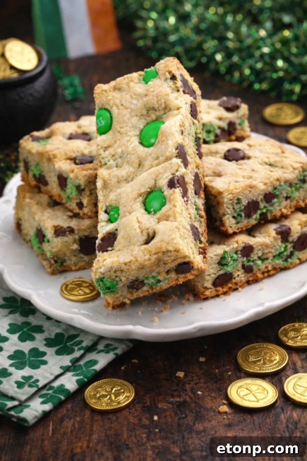 St. Patrick's Day Lucky Charm Cookie Bars 2 Saint Patrick's Day Chocolate Chip Cookie Bars on a white plate with st paddys day decor