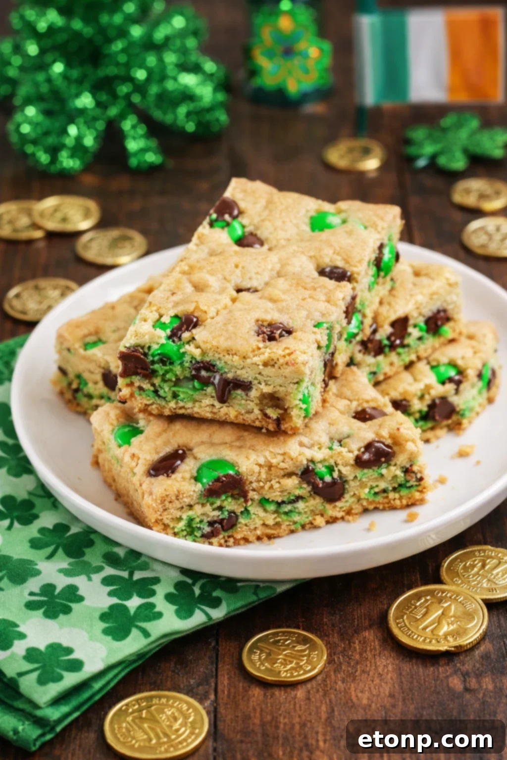 St. Patrick's Day Lucky Charm Cookie Bars 5 side view of Saint Patrick's Day Chocolate Chip Cookie Bars on a white plate with st paddys day decor