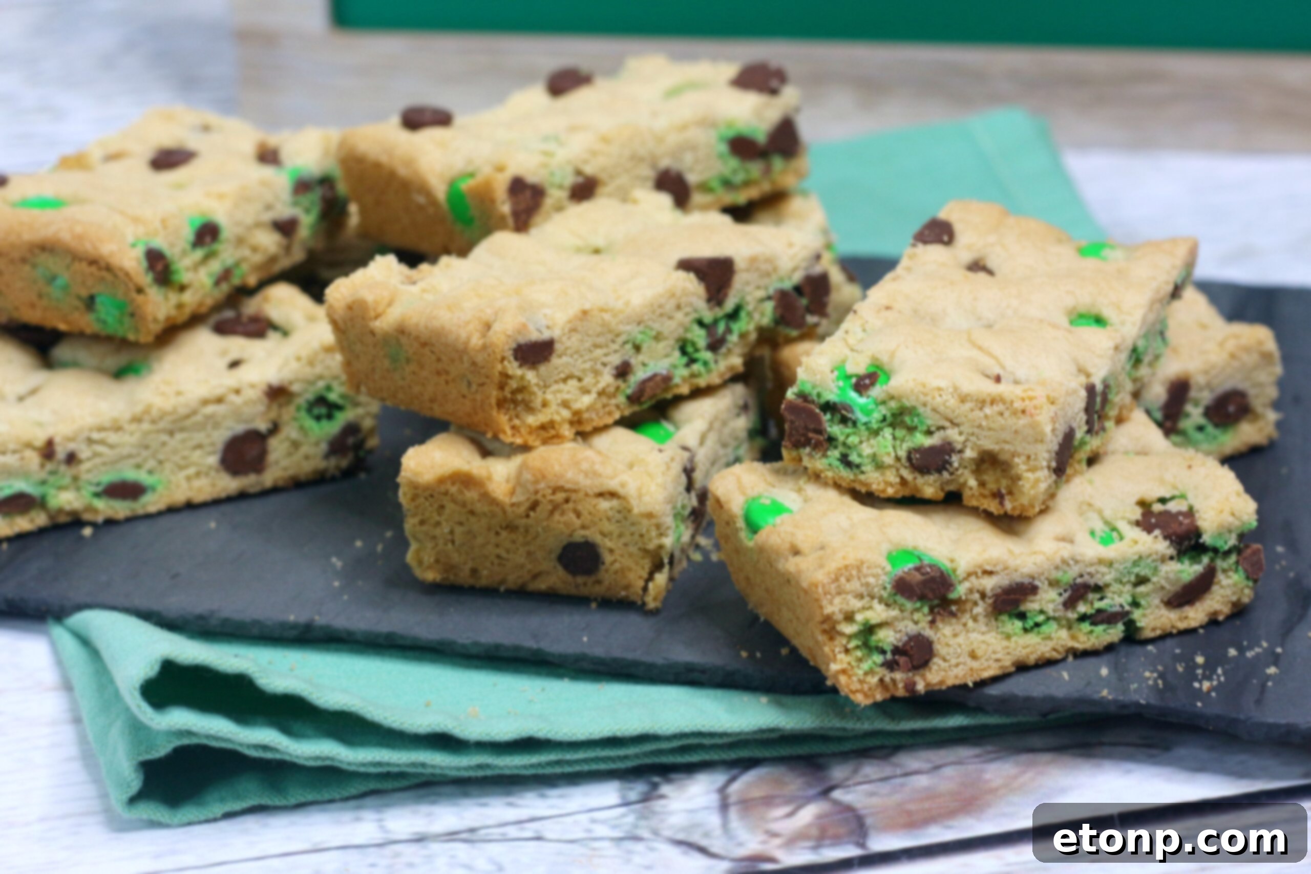 St. Patrick's Day Lucky Charm Cookie Bars 6 Saint Patrick's Day Chocolate Chip Cookie Bars on a black serving tray with st paddys day decor