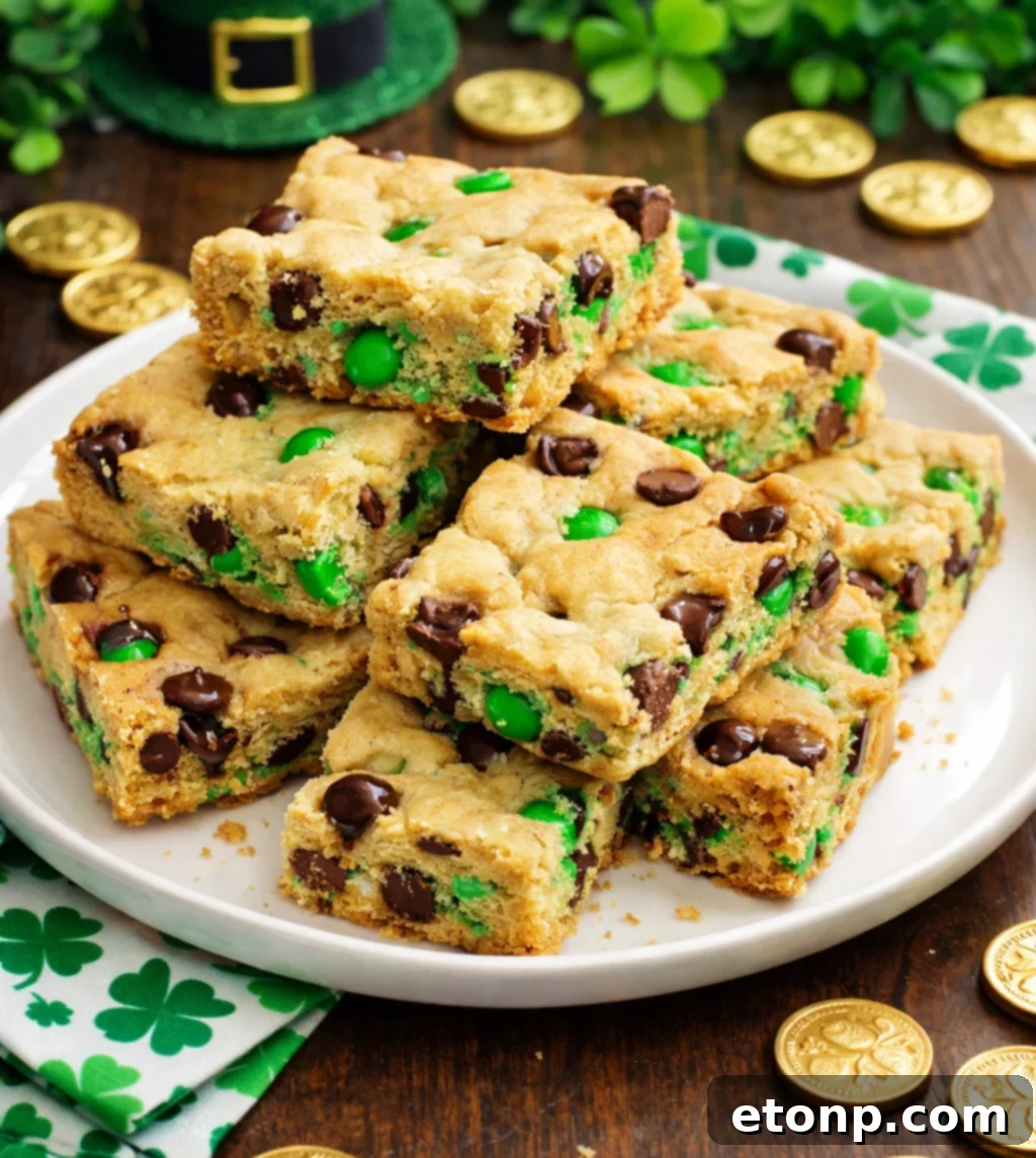 St. Patrick's Day Lucky Charm Cookie Bars 8 stacked image of Saint Patrick's Day Chocolate Chip Cookie Bars on a white plate with st paddys day decor