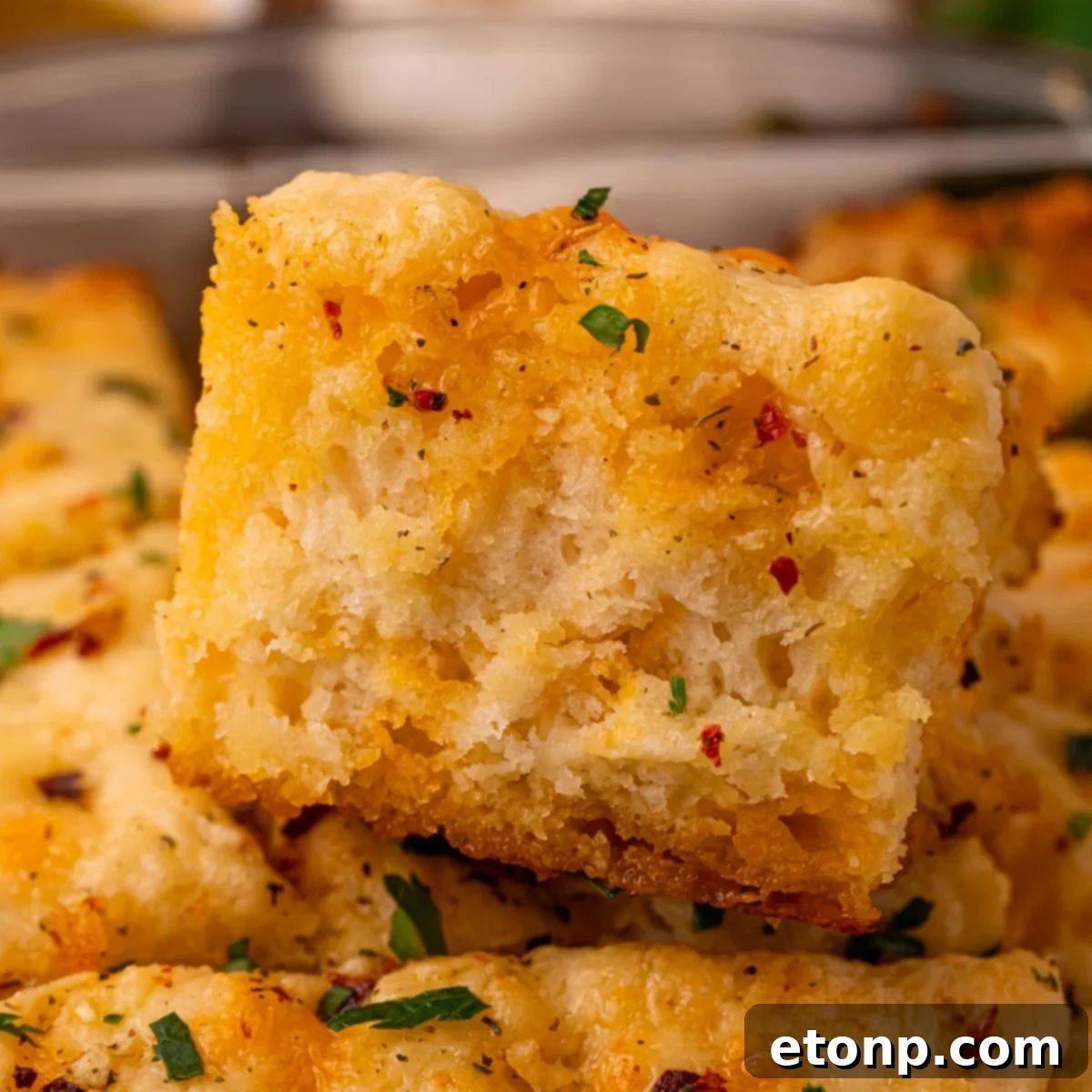 Effortless Butter Drenched Cowboy Biscuits 2 A pan of freshly baked Cowboy Butter Swim Biscuits, with one biscuit pulled forward to show its fluffy texture.