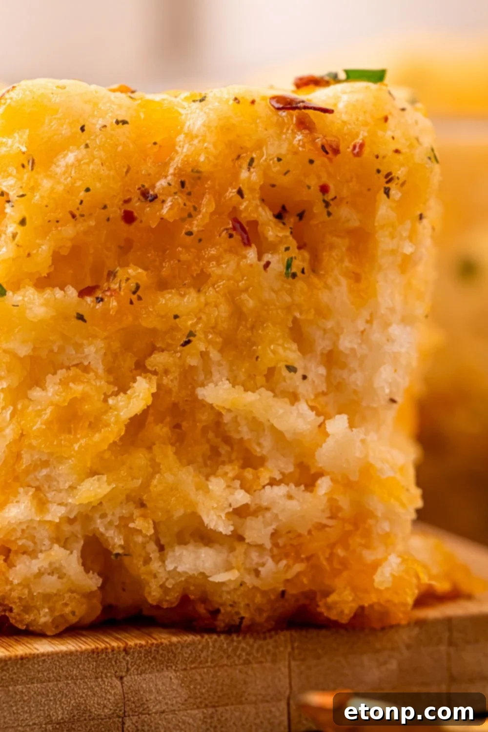 Effortless Butter Drenched Cowboy Biscuits 8 An extreme close-up shot of a single Cowboy Butter Swim Biscuit, highlighting the herbs and fluffy texture.