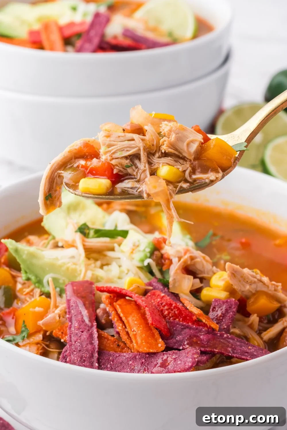 Southwestern Chicken Soup in a white bowl with a spoon full of soup lifting out of the bowl 