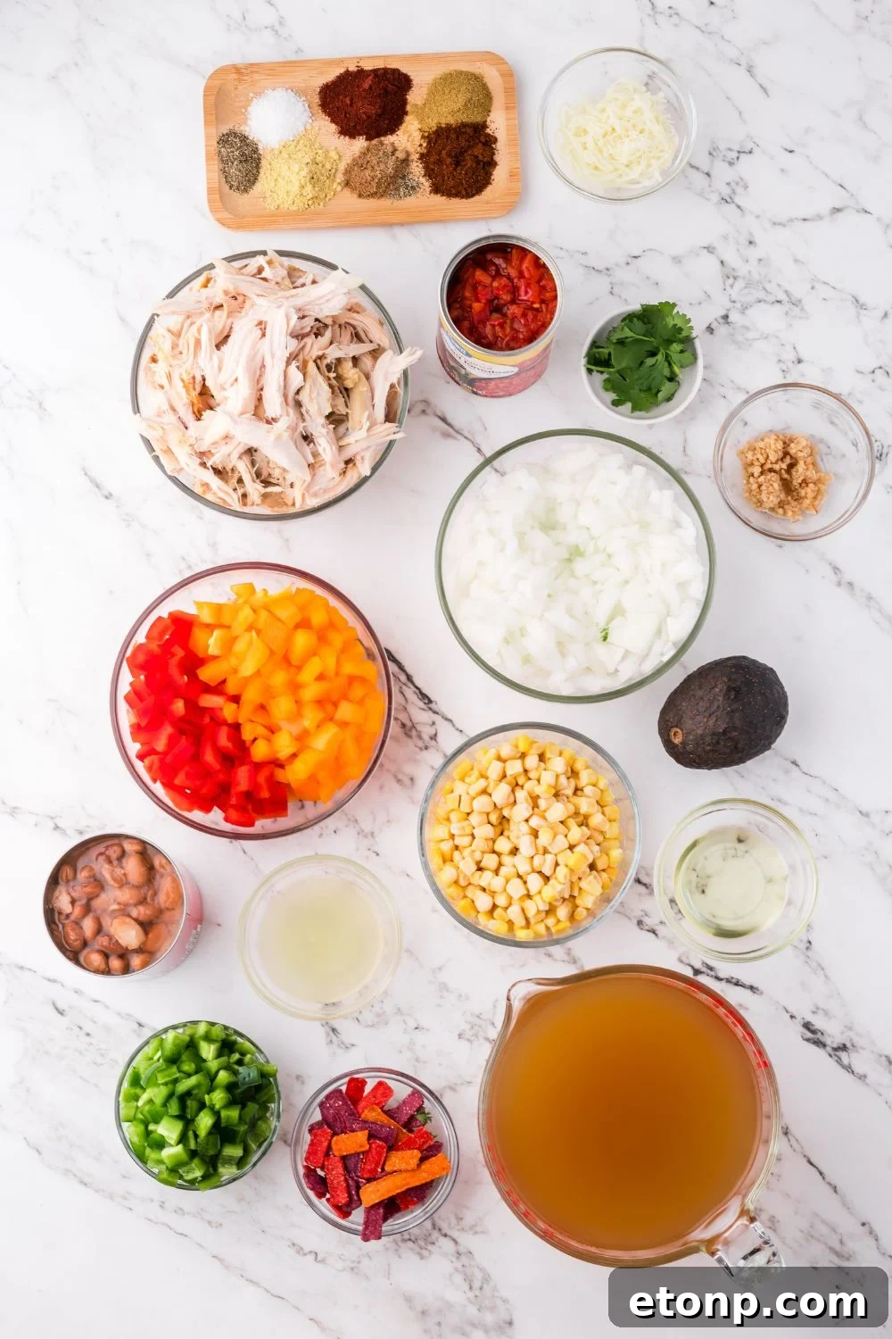 all the ingredients for Southwestern Chicken Soup in single serve bowls on a marble counter 