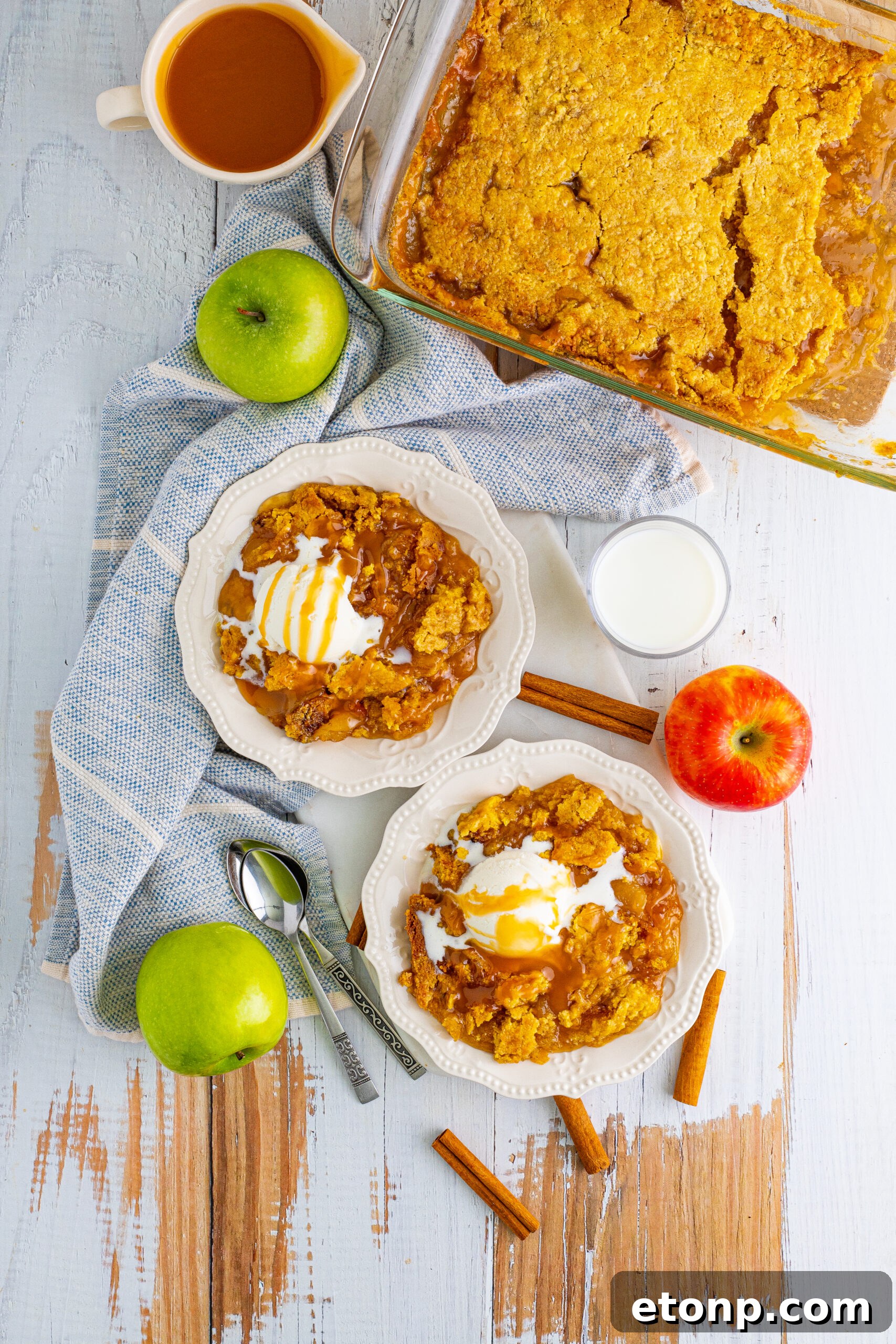 Overhead shot of Caramel Apple Dump Cake on two white plates with a blue and white linen.